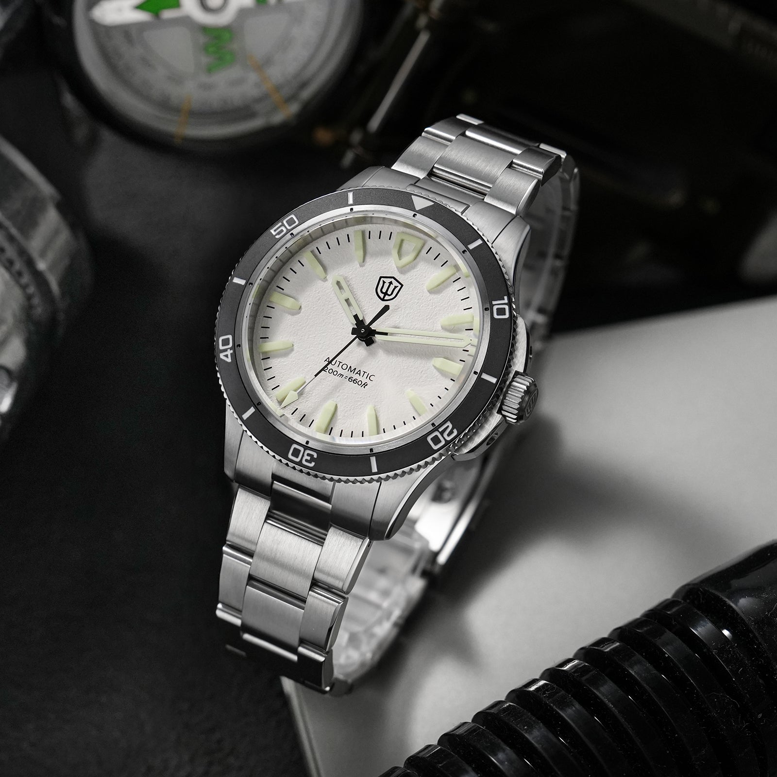 White-dial Watchdives WD0019 with raised hour markers, a dark bezel and steel bracelet, without a visible date window